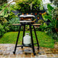 Portable grill on a stand with a propane tank in an outdoor garden setting